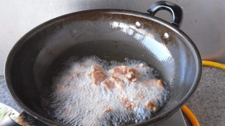 锅包肉, 把油温提高到7成热，放入肉片复炸一次，炸制到外表发硬，捞出备用 