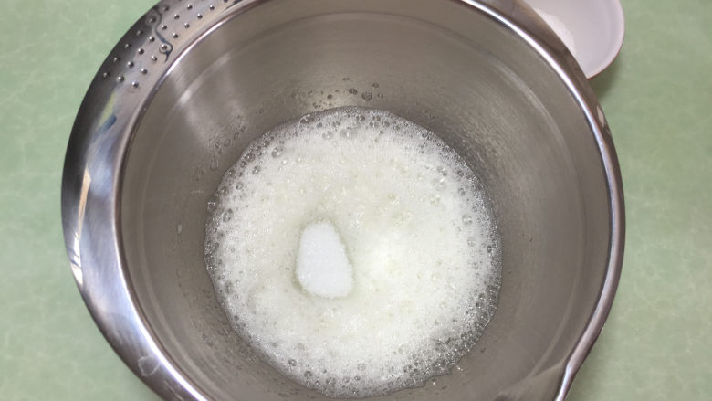 形彩绘芒果蛋糕卷,接下来打发蛋白，先用电动打蛋器将蛋白打至粗泡，然后第一次加入1/3细砂糖。