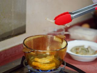 私房酱汁闷虾,煎锅中倒油，2cm高左右，中火加热油后，把虾逐个放入油锅，正反面炸脆。
（倒半锅油，直接煎炸所有虾也行，只是浪费油）