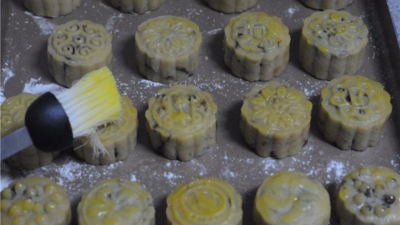 红豆莲子月饼,取出来刷上稀释蛋黄液，入烤箱，180度烤15分钟至表面微微变黄即可