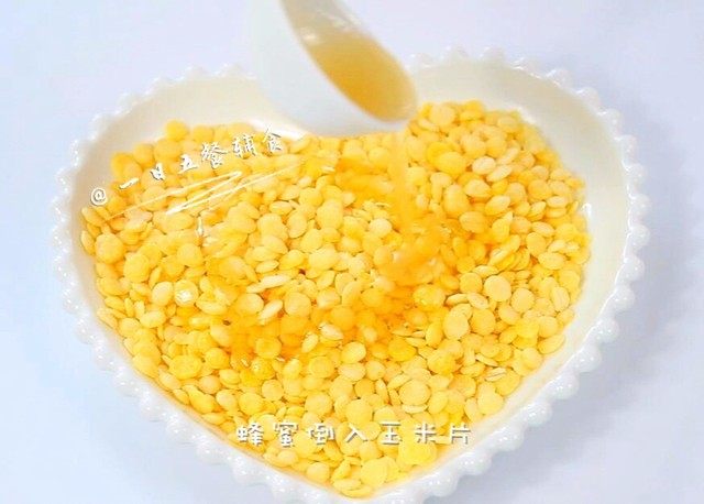烤玉米片,核桃油、蜂蜜都倒入玉米片中。
🌻小贴士：不放蜂蜜，放白糖也可以，加糖要先烤5分钟，拿出来翻面再烤。