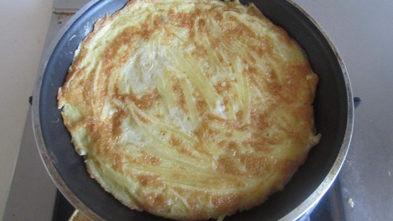 土豆丝饼,微微煎至定型后翻个面将另一面煎至金黄，撒些小葱末， 上桌了。