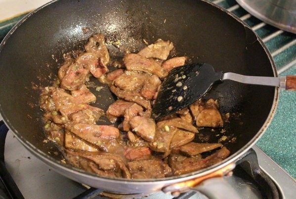南煎肝,放入猪肝翻炒两下，加入事先调好的酱汁，迅速翻炒让猪肝均匀裹上酱汁。