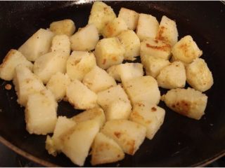 孜然土豆,将土豆放入，小火煎至表面微焦定型。