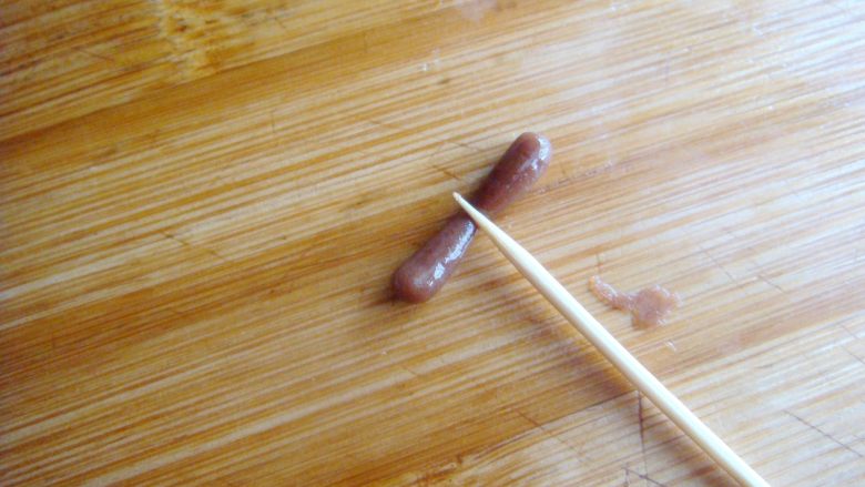 琵琶烧果子,取可可面团搓小一点的长条，一分为二，成豆粒大小做弦轴。