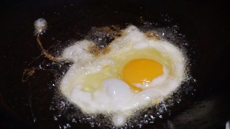 酒酿煎蛋,7.锅内倒油烧热，将鸡蛋放入锅中炸至蛋清变酥脆


叨叨叨：鸡蛋酥脆的秘诀：1.火一定要大，呼哧呼哧几下鸡蛋就泡发起来
2.油一定要多一点，