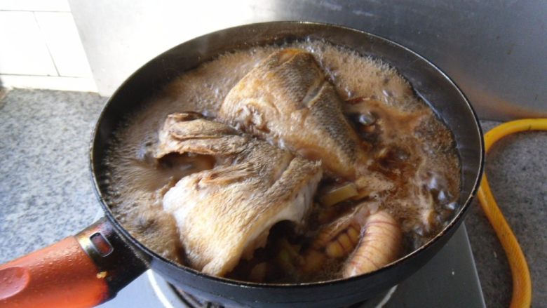 红烧鲈鱼, 加适量清水，烧制5分钟

