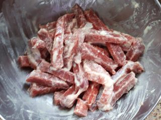 糖醋牛肉里脊,把牛里脊切成条，切成小指粗的样子，不要切得太厚哦。放入盐、面粉、淀粉、泡打粉和味淋进行调拌。
