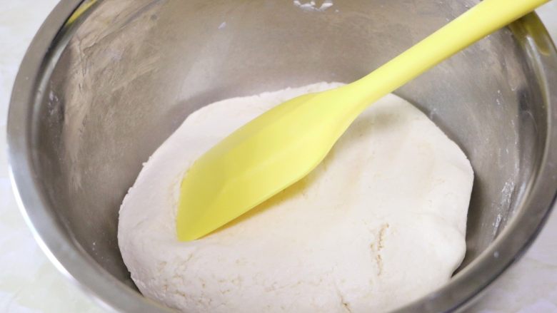 蛋黄肉松麻薯球,用刮刀慢慢按压拌匀，直至面团光滑不粘盆（如果此刻面团过粘，可加入少许糯米粉调整）
