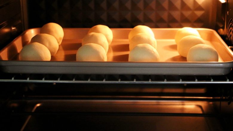 蛋黄肉松麻薯球,将烤盘放入预热好的烤箱中层，上火150度，下火130度，烘烤35分钟