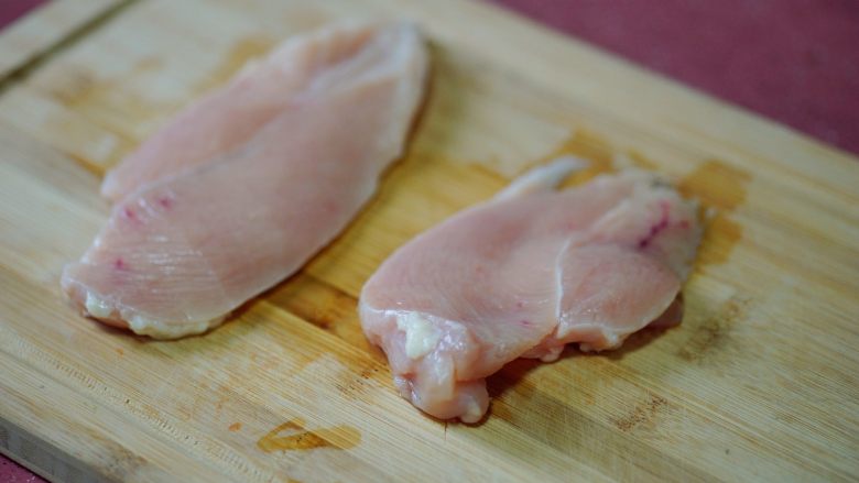 香辣秋葵手撕鸡,为了快手作业，将鸡胸肉横切，片成两块更薄的鸡胸肉。这样腌制和煮的环节都更入味，更快熟