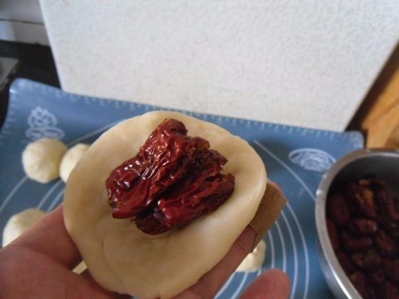 红枣烤馒头,取一个面团按扁，放入适量的红枣 