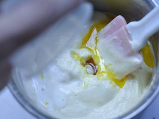 枣夹核桃蛋糕,10、将牛奶和玉米油均匀洒在蛋糊表面，再次从蛋盆底部划Ｌ状拌匀