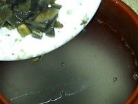皮蛋粥——品臻客五常稻花香粥米,将浸泡好的米连水一同倒入炖盅，倒入一半皮蛋末