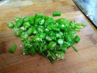 豆角煲仔饭,把青椒洗净，用刀背拍一个青椒后，切成小节节状。
