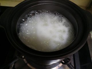 豆角煲仔饭,大米煮开后，把小木勺搅拌一下，然后小火焖煮。