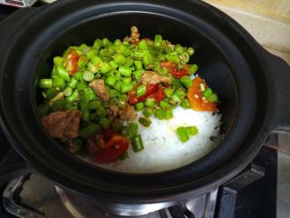豆角煲仔饭,把炒好的豆角放在快收水的米饭上。