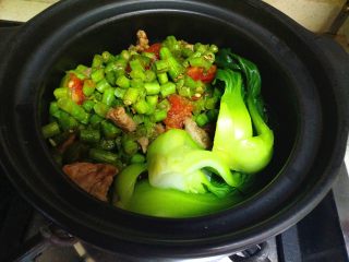 豆角煲仔饭,把洗净、焯水好的蔬菜放在米饭上，盖上砂锅盖焖2分后。