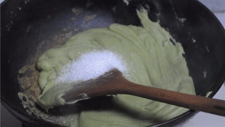 红薯叶绿豆糕,分两次加入油，炒制面糊变得浓稠后加入糖，继续翻炒