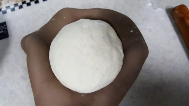  天然酵种割口欧包,面团发酵至原体积的两倍大，有明显的气孔后揉圆，把外皮擀开
，包好面团。