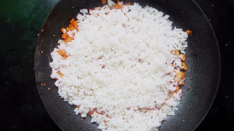 台式凤梨饭,加入米饭和1勺盐翻炒2分钟。做炒饭的大米饭要不硬不软炒饭口感才会更好呢。