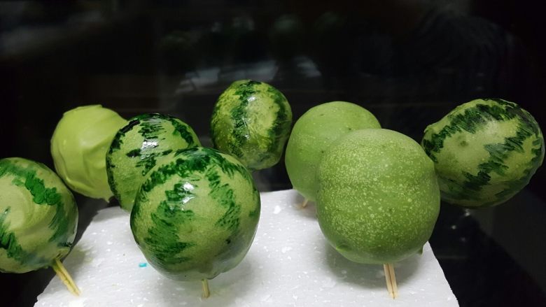 迷你小西瓜,当巧克力液完全凝固以后，取适量可食用色素，用绿色色素用笔蘸赞赏画出西瓜的纹路，这样小西瓜就做好了