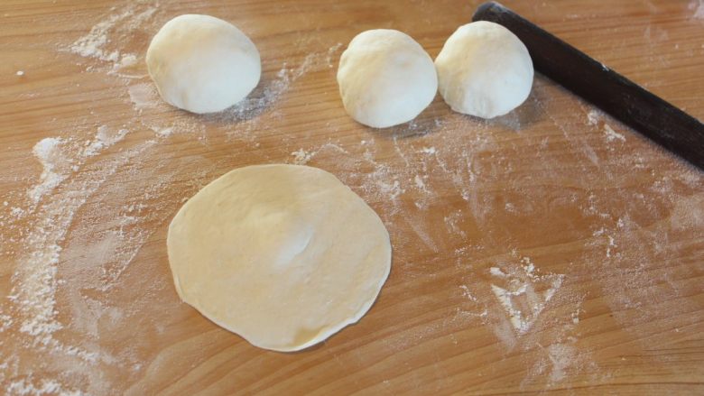 红豆饼在家做,将面团杆成中间稍厚的圆形面皮。