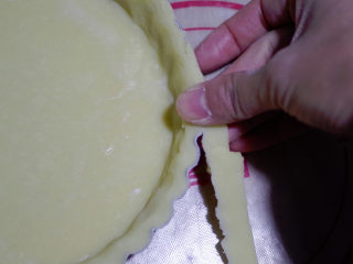 黄桃乳酪派,用擀面杖切去多余的边缘，也可以直接用手指去除多余的部分。
