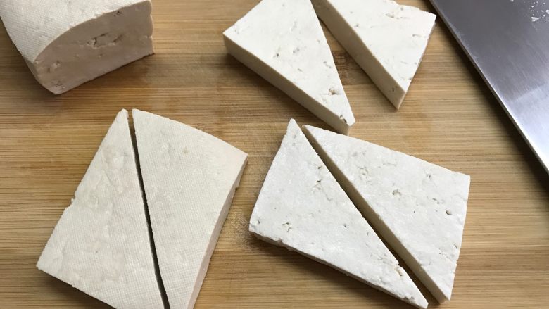 家常香煎豆腐,3、再把豆腐块对切成三角形。