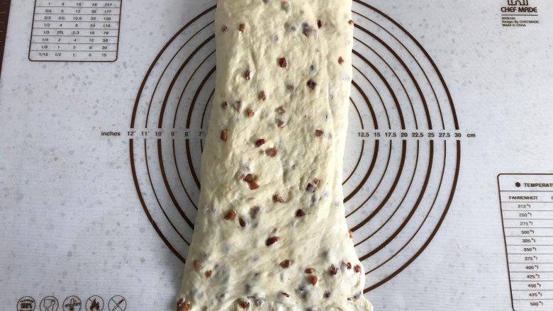 面包机版红枣果仁面包,将面团90度转向后，擀成长条形，底部压薄。