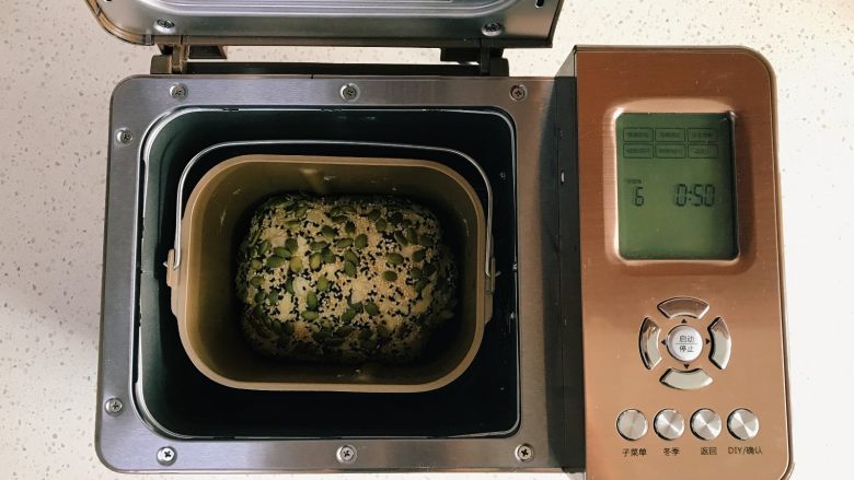 面包机版红枣果仁面包,将面团放入面包机桶内，选择发酵，时间为50分钟。