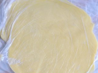 酥皮大泡芙,这时候取出酥皮，上下覆盖保鲜膜操作，擀成薄片。