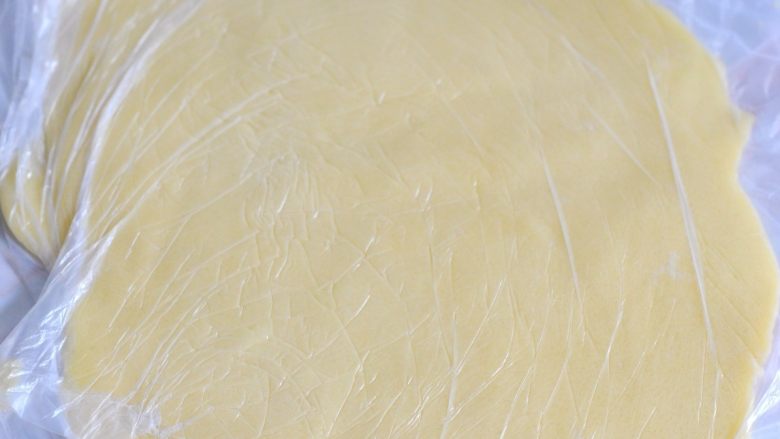 酥皮大泡芙,这时候取出酥皮，上下覆盖保鲜膜操作，擀成薄片。
