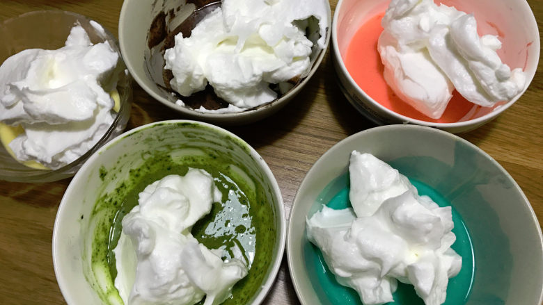 五彩蛋糕卷,将蛋白霜分别装入之前的五色碗中，每份蛋白霜大约40g。
