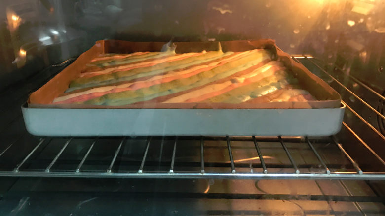 五彩蛋糕卷,放入预热好的烤箱，175度上下火烤箱中层，烘烤25分钟左右。