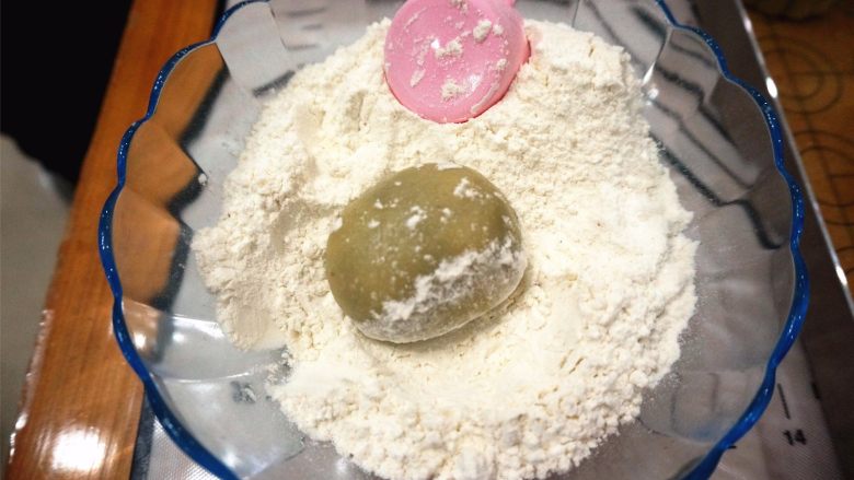 50克广式红豆蓉月饼,在中筋粉里滚一圈，同时模具也撒上干粉，倒出多余的。