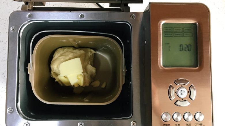 可可双色面包（面包机版）,10分钟和面结束，放入黄油，再次启动和面20分钟。