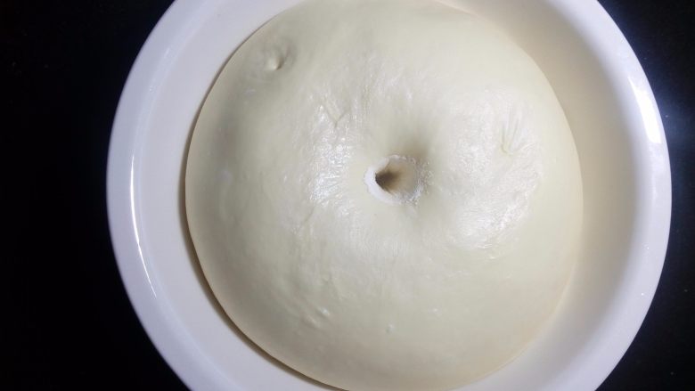椰蓉花环面包,发酵至约2倍大左右，用手指蘸粉后戳孔不回弹也不会塌陷，就完成了基础发酵，也就是我们常说的一发。
