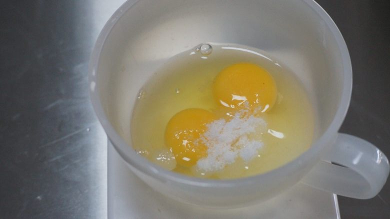 蓝莓布丁派,取一个小碗加入两个鸡蛋，和布丁用的细砂糖20g