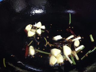 无肉不欢+爆炒麻辣兔肉,倒入蒜瓣和1/3的香葱炒出香味