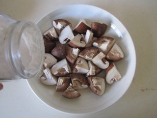香菇蒸鸡,香菇切成小块后放入盘中， 放入少许盐拌均匀；