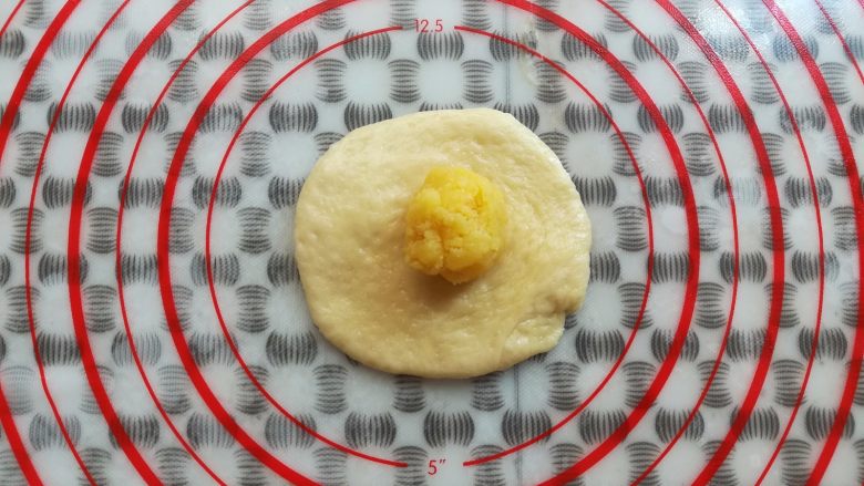 奶黄小餐包,取一个面团用擀面杖擀平放上奶黄馅