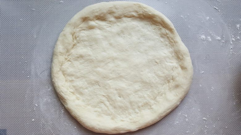 鸡肉海鲜披萨,13．用手捏成四周略厚的圆型披萨底。
