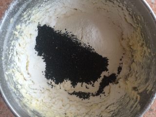黑芝麻曲奇,加入黑芝麻。用刮刀将面粉和黄油充分拌匀，至看不到面粉颗粒。
