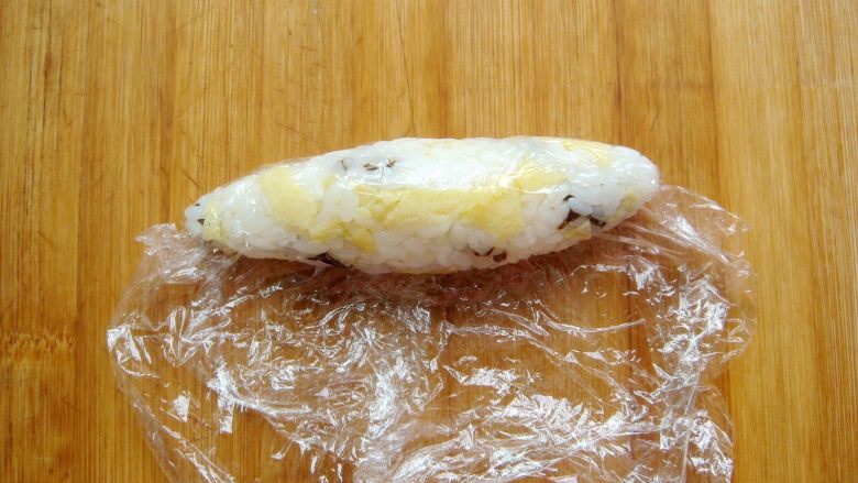 锦鲤寿司,取约40克米饭，用保鲜膜团成椭圆形。