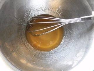 青汁月饼,将转化糖浆、花生油倒入打蛋盆，用手抽不停搅拌至充满小气体。