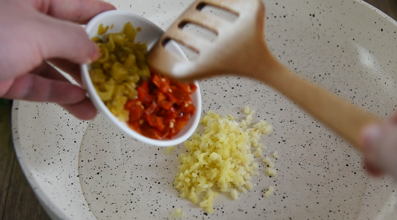 金针菇好吃又简单的做法，超级下饭哦！,油锅倒入姜蒜沫、红黄泡椒炒匀