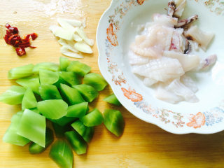 鱿鱼和蔬菜系列之莴笋炒鱿鱼,干辣椒切成小段，蒜切成片，莴笋滚到块，都备用。