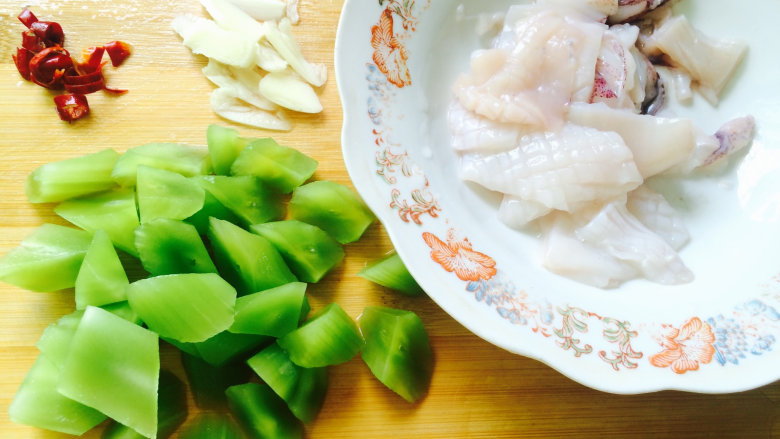 鱿鱼和蔬菜系列之莴笋炒鱿鱼,干辣椒切成小段，蒜切成片，莴笋滚到块，都备用。