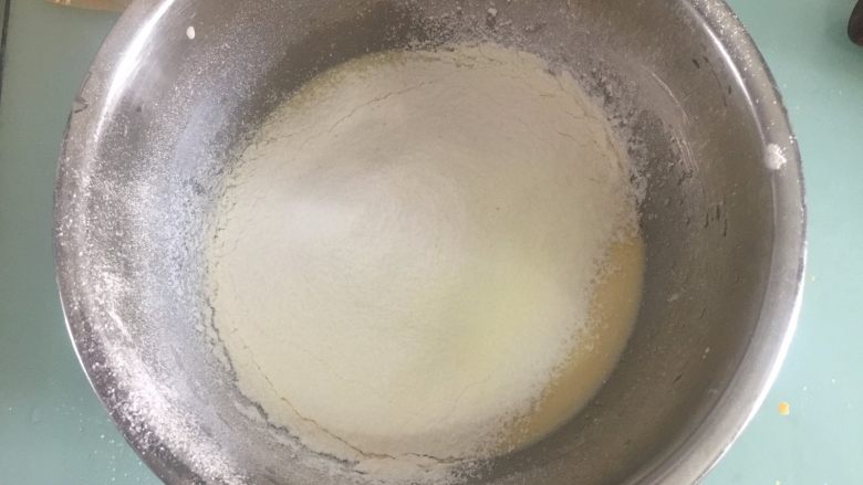 流心奶黄月饼,再混合筛入低粉、玉米淀粉和奶粉，搅拌均匀至无粉粒面糊